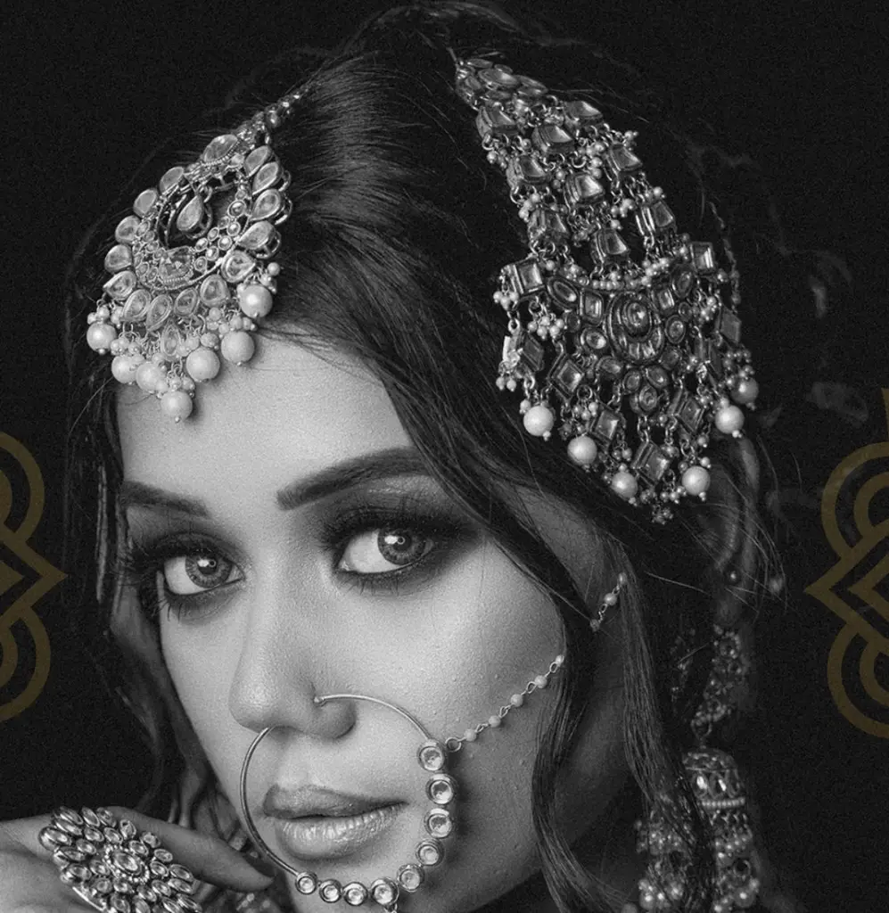 Aayra bride in black and white, wearing a jewelled maang tikka, nath and earrings